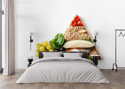 a triangle shaped pyramid plate with various foods on it Wall mural