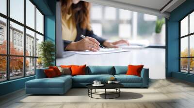 Asian indian Female director working in the office sitting at a desk analyzing business statistics holding diagrams and charts using a laptop computer, Wall mural