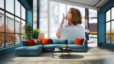 asian woman work at laptop thinking of problem solution, thoughtful female employee pondering considering idea looking at computer screen making decision
 Wall mural