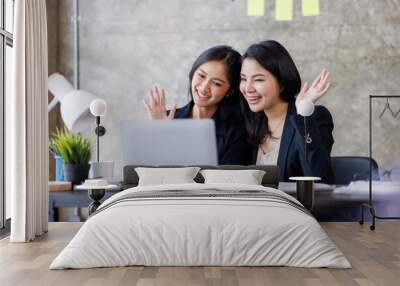 Asian Young Businesswoman attending video conference on laptop computer online co worker leaning at office monitor with professional working Wall mural