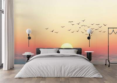 Birds flying over a colorful sunrise above fluffy clouds in the early morning sky Wall mural