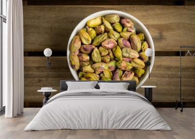 Bowl with healthy nuts, pistachios on dark wood background Wall mural