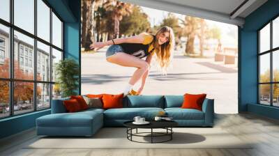 Skater girl riding a long board skate. Cool female urban sports. California style outfit. Woman on skateboard wearing pink glasses Wall mural