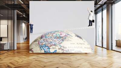 Business figures placed on a ladder balancing on an earth globe. Wall mural