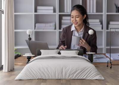 Cropped photo of Asian business woman holding coffee cup with a beverage during a coffee break at the workplace. Business concept
 Wall mural