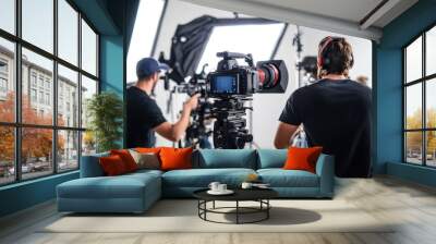 Film crew working on a set with cameras and bright lighting during a production day Wall mural