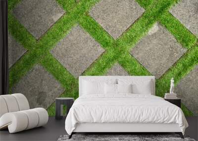 Flat lay shot of tile pavement close-up with artificial green grass diagonal. Abstract background texture. Wall mural