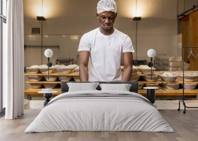 young black man working in a bread factory, learning the trade. Wall mural