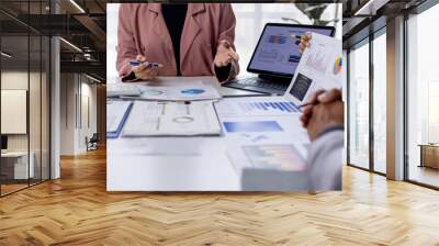 Group of confident business people point to graphs and charts to analyze market data, balance sheet, account, net profit to plan new sales strategies to increase production capacity.  Wall mural