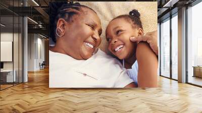 Happy, smile and family of a black grandma and child in happiness relaxing and lying on a bed at home. Senior African grandmother and little girl in joyful, love and smiling together in the bedroom Wall mural