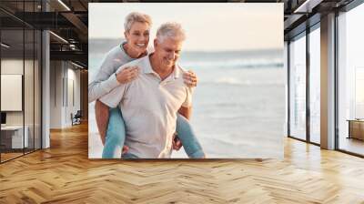 Love, beach and piggyback with a senior couple walking by the sea or ocean while on a date in summer together. Nature, earth and water with an elderly man and woman pensioner taking a walk on a coast Wall mural