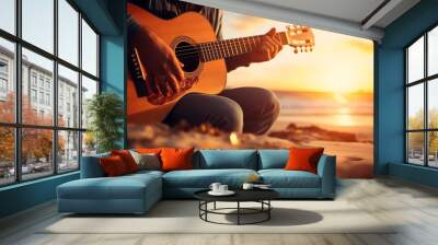 Persona tocando una guitarra frente a un atardecer de playa, creando un ambiente relajado y musical Wall mural