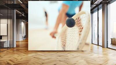 Man, playing and court or squash match, rubber ball and racket for sport with energy or fitness in challenge. Athlete, serve and competing in active hobby, wooden floor and training for competition Wall mural