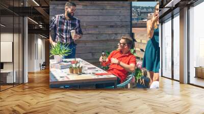 Group of friends talking and drinking at a party on a terrace Wall mural