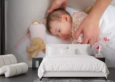 Hands of mother caressing her baby girl sleeping Wall mural