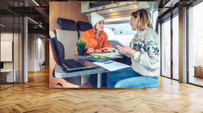 Women telecommuting during a camper van trip Wall mural