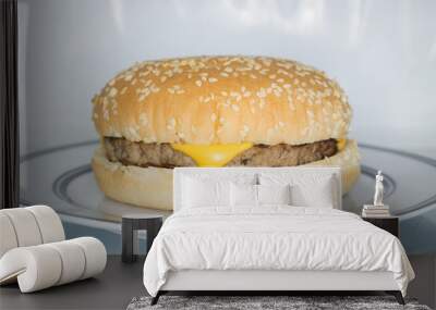 Microwavable cheese burger in a sesame seed bun in a microwave oven an example of modern fast food Wall mural