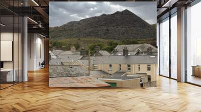 Unsightly mining spoil tips towering above houses and roof tops in the Welsh town of Blaenau Ffestiniog UK Wall mural