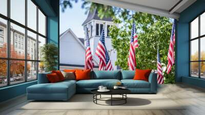 American flags waving outside white church steeple in daylight Wall mural