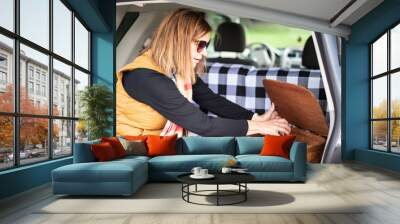 woman opening picnic basket in back of car Wall mural