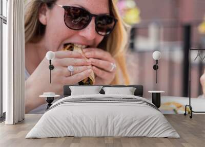 woman taking a bite of a taco Wall mural