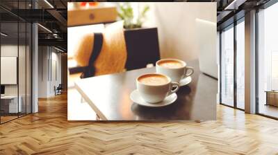 two lattes on a black table in a coffee shop with a hat Wall mural