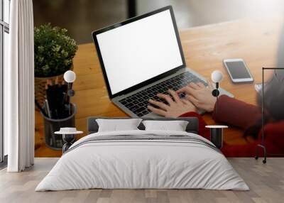 Woman hand using a laptop and sitting on the office in the house, mock-up of a blank screen for the application. Wall mural