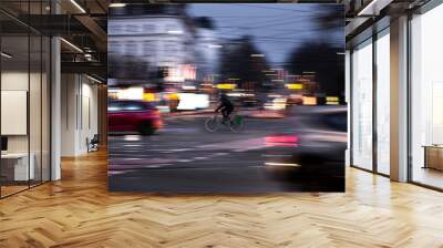 A cyclist drives at twilight over a road intersection Wall mural