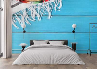 mexican background with sombrero straw hat and traditional serape rug or blanket on old blue planked Wall mural