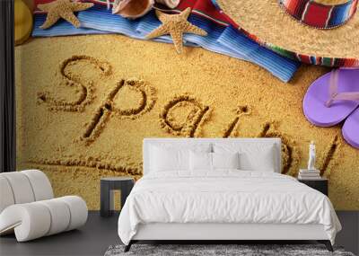 Spain word written in sand on a sandy beach background with star fish and accessories summer Spanish holiday vacation photo Wall mural