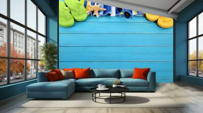 Summer beach background border with sunbathing towel sunglasses and accessories on old blue wood decking deck photo Wall mural