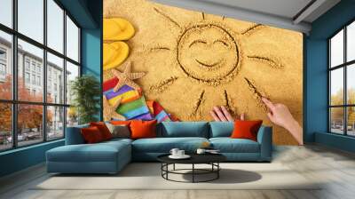 Summer beach smiling sun happy smiley face drawing drawn in sand with accessories holiday vacation photo Wall mural