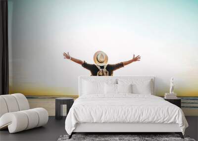 Back view of happy excited man raising arms up to blue sky - Hipster winner traveler enjoying summer sunset at the beach - Travel, mental health, success, business, tourism and life style concept Wall mural