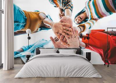 Community of millennial people stacking hands together - Multiracial college students putting their hands on top of each other - Human relationship, social, community and team building concept Wall mural