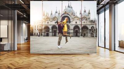 Couple of tourists visiting Venice, Italy - Boyfriend and girlfriend in love having fun on city street at sunset - People, love and holidays concept Wall mural