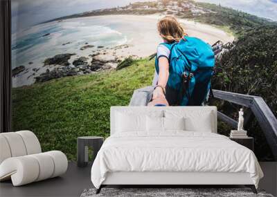 Couple summer vacation travel. Woman walking on romantic honeymoon promenade holidays holding hand of husband following her, view from behind Wall mural