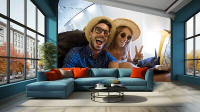 Crazy and happy couple take selfie on the airplane during flight. Concept about travel, lifestyle and happiness Wall mural