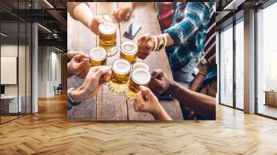 Group of people enjoying and toasting a beer in brewery pub - Friendship concept with young people having fun together Wall mural