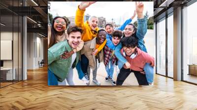 Group of young people with hands up looking at camera - Millenial friends having fun together on city street - Multicultural students walking outside university campus - Youth culture and scholarship Wall mural