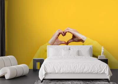 Hands making heart shape isolated on a yellow background - Love and minimal fashion concept Wall mural