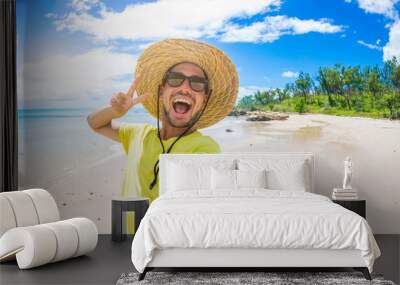 Handsome man having fun taking a selfie at the beach on holiday Wall mural