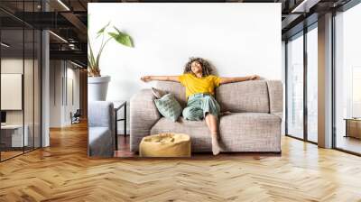 Happy afro american woman relaxing on the sofa at home - Smiling girl enjoying day off lying on the couch - Healthy life style, good vibes people and new home concept Wall mural