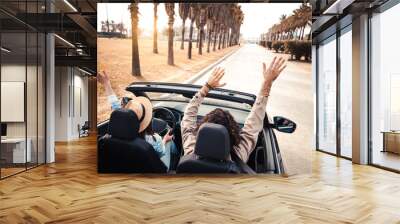 Happy couple driving on city street in convertible car - Friends rent cabrio auto on vacation - Roadtrip, freedom, travel and transport rental service concept Wall mural