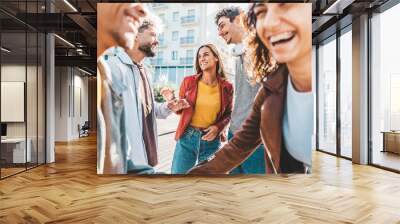 Happy multiracial friends having fun together walking on city street - Group of young people hanging out in town on a sunny day - University students talking and laugh out loud in college campus Wall mural