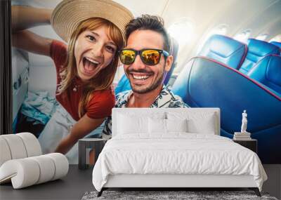 Happy tourist taking selfie inside airplane - Cheerful couple on summer vacation - Passengers boarding on plane - Holidays and transportation concept Wall mural