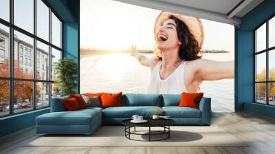 Happy woman with arms outstretched enjoying freedom at the beach  Wall mural