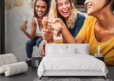 Laughing teenage girls eating ice cream cones on city street - Young female friends enjoying icecream outside - Summer lifestyle concept Wall mural