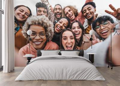 Multicultural community of young people smiling together at camera - Happy diverse friends taking selfie picture with smart mobile phone device - Friendship and human relationship concept Wall mural