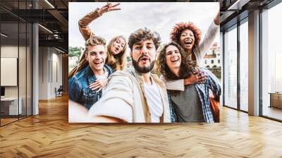 Multicultural happy friends having fun taking group selfie portrait on city street - Young diverse people celebrating laughing together outdoors - Happy lifestyle concept. Wall mural