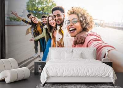 Multiracial friends group taking selfie pic with smartphone outside - Happy young people having fun walking on city street - Friendship concept with guys and girls enjoying summertime day outside Wall mural